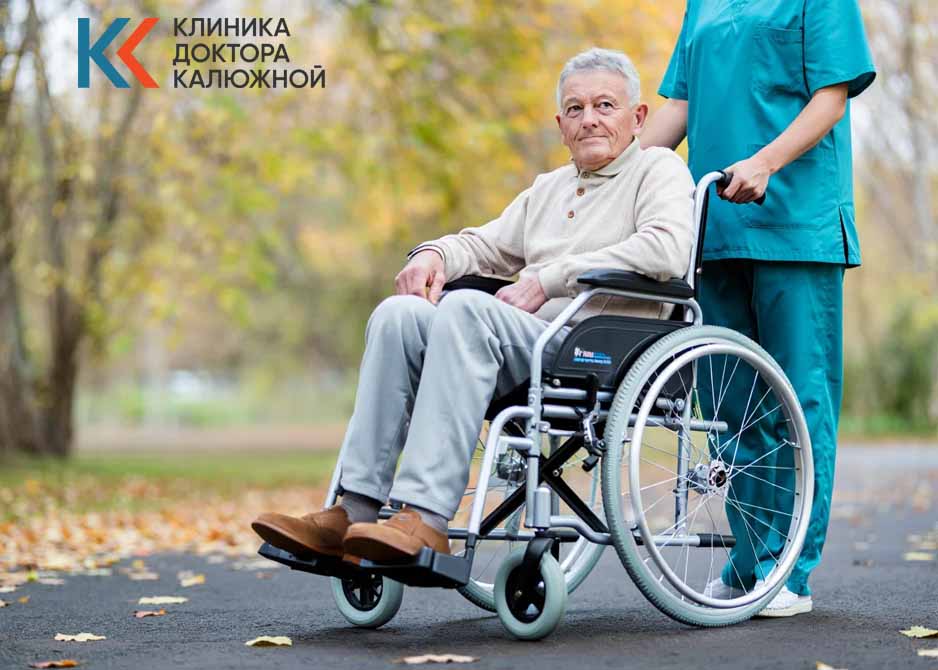Медработник везет мужчину с ограниченными возможностями Медработник везет мужчину на кресле-коляске